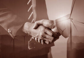 Double,Exposure,Graphic,Of,Business,People,Handshake,Over,Wind,Turbine Offentlige-anskaffelser-wahl-larsen-advokat.jpg